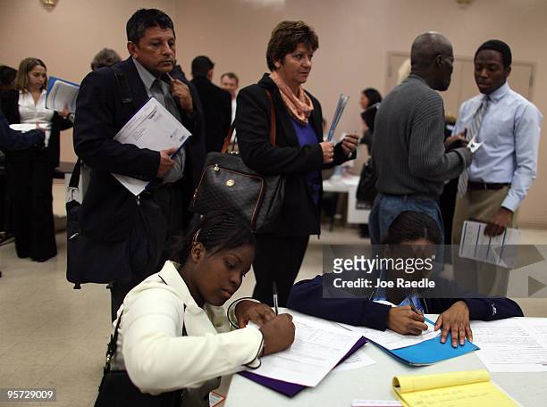 Danna Thompson and Keisha Thompson fill out job applications as they attend the Village at Gulfstream Park job fair on January 12, 2010 in...