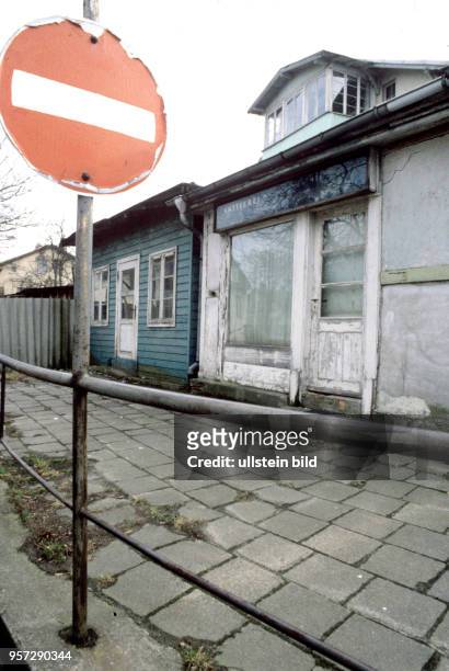 Verfallene kleine Häuser an einer Straße im Ort Ahlbeck auf der Insel Usedom, undatiertes Foto vom Märzu 1981. Im rechten Landengeschäft arbeitete...