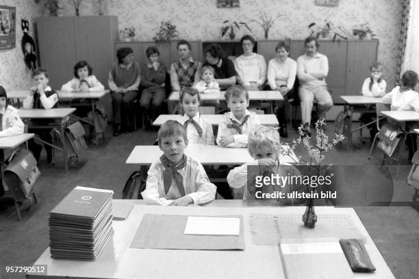 Schüler in Pionierkleidung warten gespannt auf die feierliche Übergabe der Zeugnisse, aufgenommen Anfang Februar 1989 in Schwerin. Die Zeugnishefte...