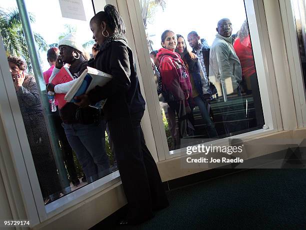 People wait for their numbers to be called to enter the Village at Gulfstream Park job fair on January 12, 2010 in Hallandale, Florida. The shopping...