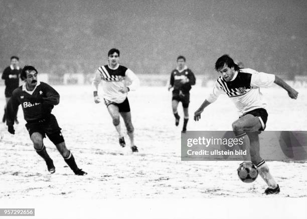Dresdens freigespielter Stürmer Ulf Kirsten versucht auf Schneeboden den Ball unter Kontrolle zu bringen. Sein Teamgefährte Ralf Minge und der...
