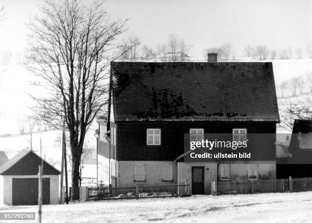 Das im Winter 1985 aufgenommene Foto zeigt das Haus der Handwerker-Familie Füchtner in Seiffen, wo u.a. Nussknacker in Handarbeit gefertigt werden....