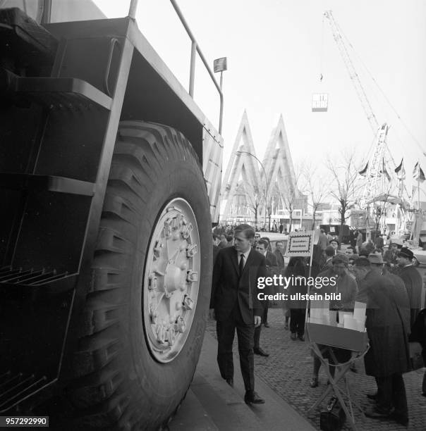 Besucher auf dem Freigelände der Technische Messe in Leipzig, aufgenommen im März 1967, im Hintergrund das doppelte "M", das Symbol der Muster-Messe....