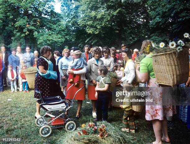 Frauen tragen Körbe mit Pflanzen beim Volksfest Grasedanz in Hüttenrode im Harz, undatiertes Foto vom August 1976. Das dreitägige Fest wird seit 1885...