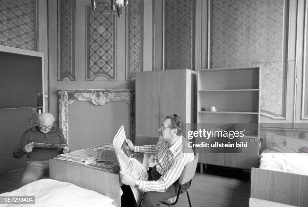 In einem Schlaf- und Wohnraum mit Betten und Schränken sitzen zwei Männer und lesen, Foto vom . Die Männer sind Patienten im Diabetiker-Sanatorium...