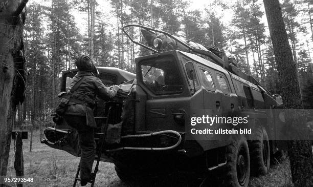 Soldaten der DDR mit Panzerhaube an einer Startrampe mit Rakete während einer Manöverübung der Flugabwehrraketentruppen, aufgenommen 1983. [Ort...