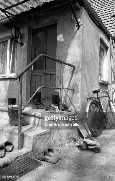 Gummistiefel stehen vor einem Wohnhaus im Dorf Alt - Tucheband im Oderbruch , aufgenommen 1982 Foto : Reinhard Kaufhold