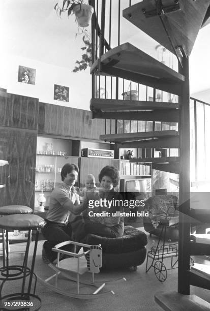 Ein Paar mit Säugling im modern eingerichteten Wohnzimmer ihrer Wohnung, aufgenommen 1977 in Berlin-Prenzlauer Berg.