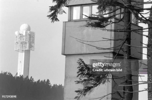 Ein Beobachtungsturm der DDR-Grenztruppen und der im Hintergrund 1972 vom US-Geheimdienst auf dem Wurmberg in Deutschland errichtete 81 m hohen Turm,...