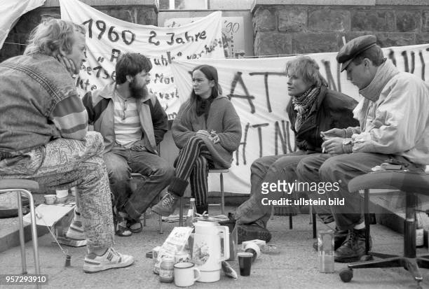 Ehemals von der Stasi verfolgte Bürger sitzen am vor der Bezirksbehörde des Ministeriums für Staatssicherheit in der Bautzner Straße in Dresden und...