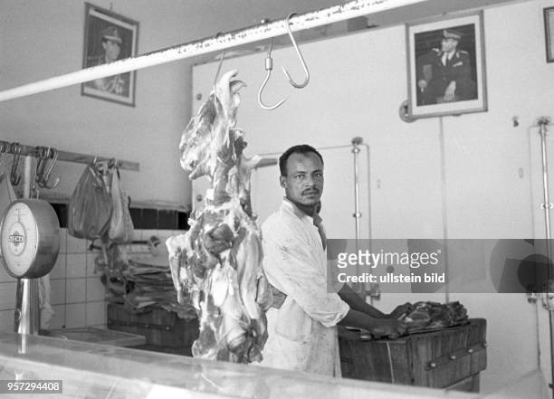 Ein Fleischer in einer Fleischerei, an den Wänden hängen Fotos des libyschen Revolutionsführer Oberst Muammar Abu Minyar al-Gaddafi, aufgenommen im...