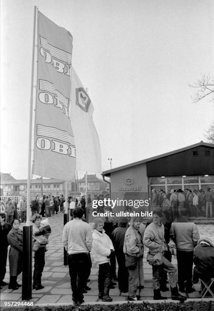 Bereits im Januar 1990 eröffnet OBI seinen ersten Baumarkt in Dresden - eine lange Menschenschlange wartet am Eröffnungstag auf den Einlaß.