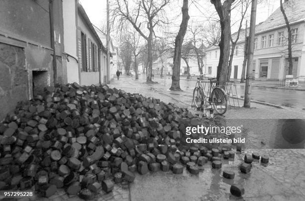 Vom Kohlehandel angelieferte Braunkohlenbrikett liegen auf einer Straße in Rheinsberg, Foto vom . Brikett waren zu DDR-Zeiten das Heizmaterial für...