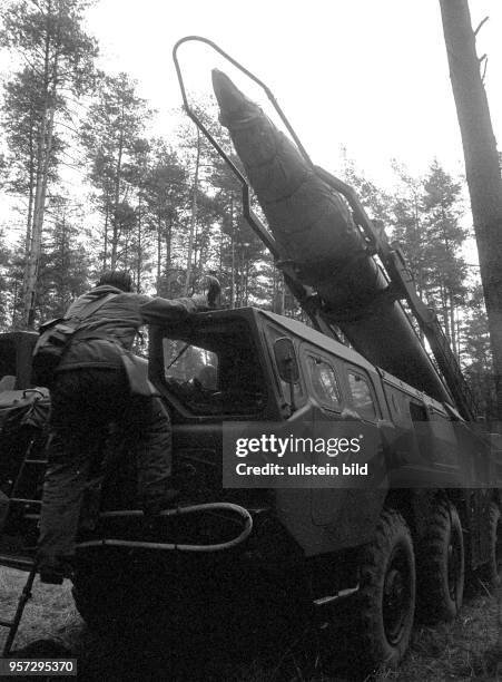 Soldaten der DDR mit Panzerhaube an einer Startrampe mit Rakete während einer Manöverübung der Flugabwehrraketentruppen, aufgenommen 1983. [Ort...