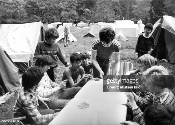 Jugendliche Bergsteiger haben ihre Zelte im Kirnitzschtal in der Sächsischen Schweiz aufgeschlagen und spielen eine Partie Karten, aufgenommen 1984....