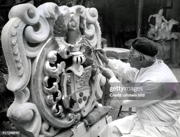 Bildhauer Werner Hempel arbeit in seiner Werkstatt in Dresden an einem Schlosswappen, aufgenommen 1976. Die bedeutende Bildhauerfirma Hempel arbeitet...