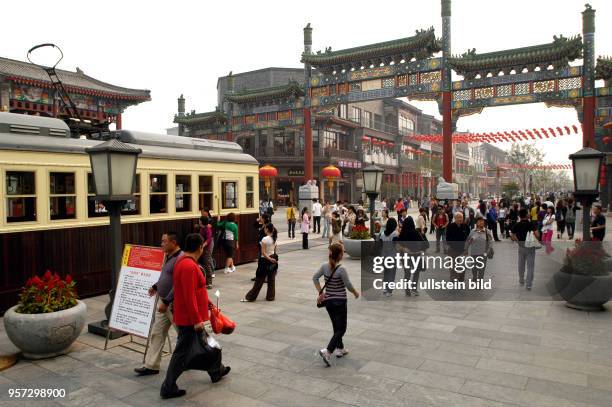 Oktober 2009 / China - Peking/ Passanten und Touristen - Eine historische Straßenbahn bringt Touristen in die sanierten alte Einkaufsstraße Qianmen...