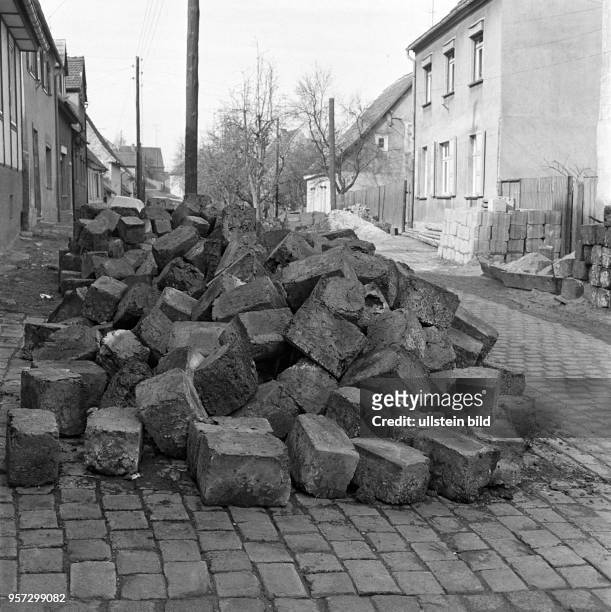 Auf einer Straße liegen Schlackensteine zur weiteren Verwendung im Straßenbau bereit, aufgenommen im Frühjahr 1974 in Helbra im Mansfelder Land. Bei...