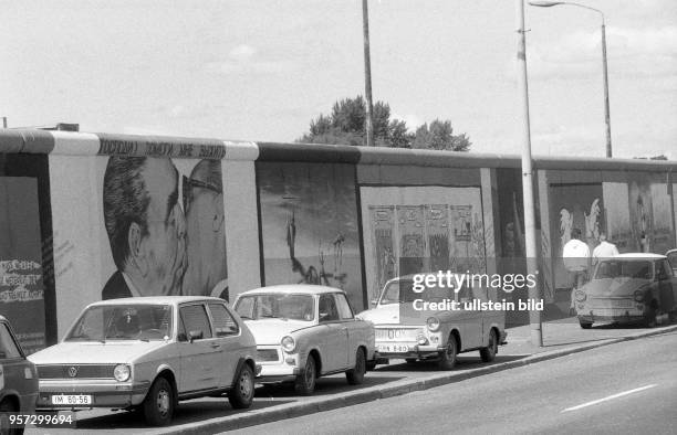 Pkw der Marke Trabant stehen an der Mühlenstrasse in Ostberlin vor den Bildern Bruderkuss , gemalt vom russischen Maler Dmitri Waldimirowitsch Wrubel...