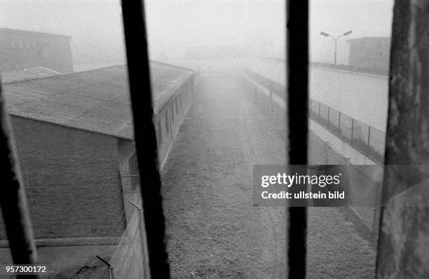 Blick durch die Gitterstäbe eines Fensters auf die Baracken und Sicherungsanlagen des "Jugendhauses" Ichtershausen im Bezirk Erfurt im Dezember 1989....