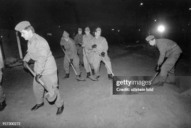 Grenzsoldaten der DDR befestigen am Potsdamer Platz nach dem Abbruch von Mauerteilen den Boden für einen provisorischen Grenzdurchgang, aufgenommen...