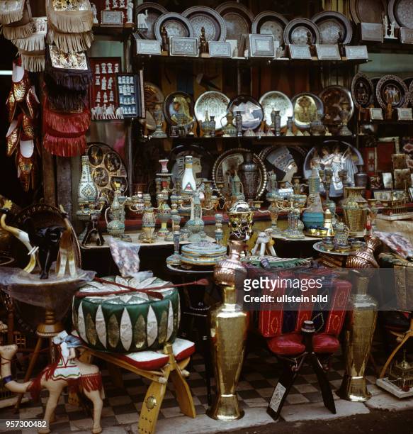 Diverse Souvenirs der arabischen Welt in Form von Messinggeschirr, Vasen, Tellern und Sitzkissen, aufgenommen in einem Basar von Kairo 1972.