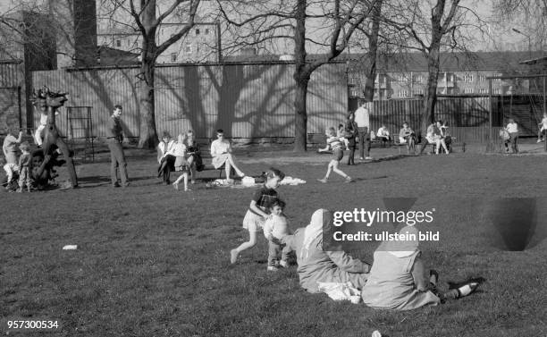 Türkische Frauen mit ihren typischen Kopftüchern und langen Kleidern sitzen auf dem Rasen im Park am Weißen See - ein bis dahin in der DDR eher...