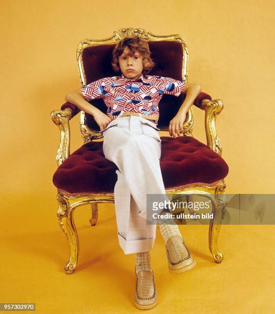 Illustration - ein Junge lümmelt in einem golldenen Sessel, undatiertes Foto vom Januar 1977.