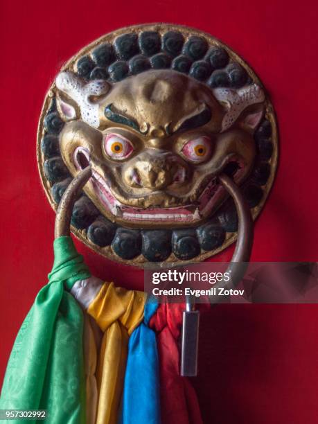 lion head shaped door handle with attached colorful khatas (buddhist ceremonial scarfs). wudang lamasery, inner mongolia, china - baotou stock-fotos und bilder