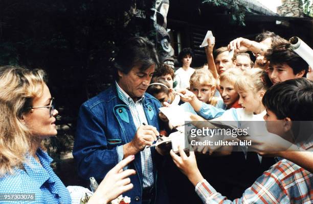 Umringt von jungen Fans schreibt der Schauspieler Pierre Brice im Juli 1988 bei seinem Besuch des Karl-May-Museums im sächsischen Radebeul...