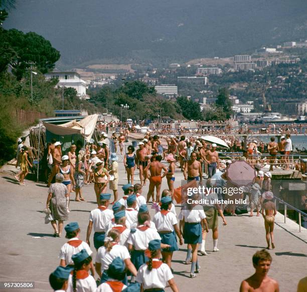 Eine Gruppe Leninpioniere aus dem nahegelegenen Pionierlager Artek spaziert entlang der Promenade des Kur- und Urlaubsortes Jalta auf der Krim,...