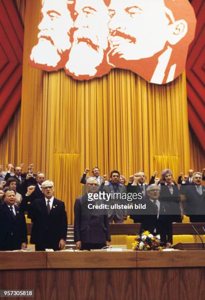 Mit erhobener Faust singen am 11.04. 1981 im Palast der Republik in Berlin zur Eröffnung des X. Parteitags der SED die Funktionäre im Präsidium die...