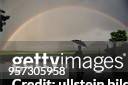 Silhouette einer Frau mit Regenschirm vor einem Regenbogen - 1995