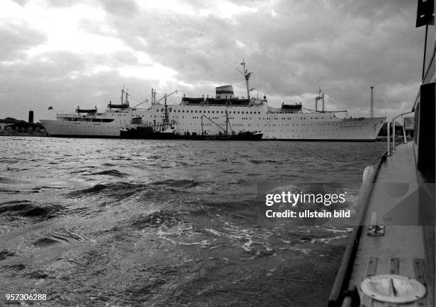 Das Lotsenboot "Wels" im Anmarsch zum Passagierschiff "Völkerfreundschaft" am Warnemünder Passagierkai, aufgenommen in den 1980er Jahren in Rostock....