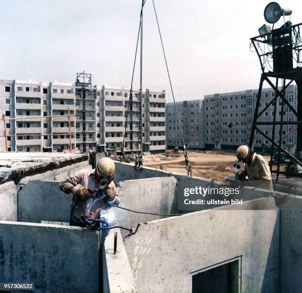 Bauarbeiter montieren am in Dresden-Prohlis Plattenelemente der Wohnbauten. Mit vorgefertigten Betonelementen war im industriellen Wohnungsbau eine...