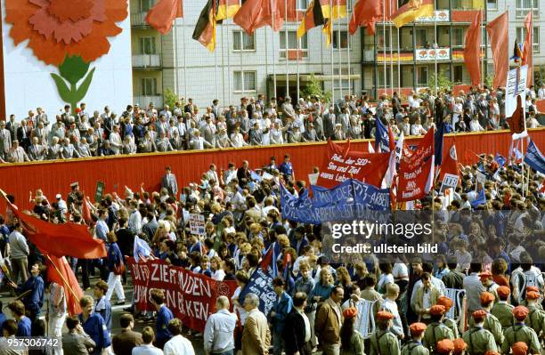 Demonstranten winken dem Vorsitzenden des Staatsrates der DDR Erich Honecker und anderen Funktionären der DDR-Partei- und Staatsführung auf der...