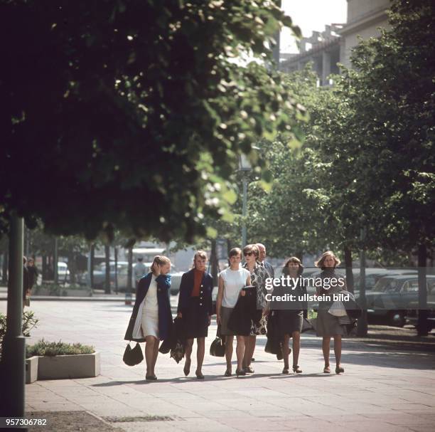 Junge Frauen laufen auf dem Mittelweg der Straße Unter den Linden in Berlin , aufgenommen im Juni 1967.