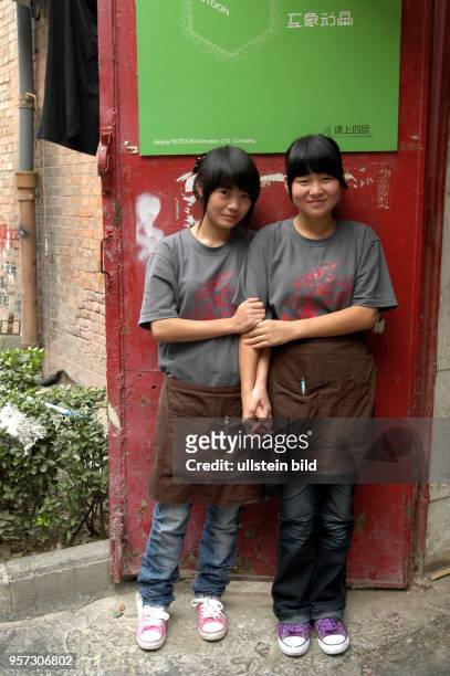 China - Peking / Zwei junge Leute, Mitarbeiter im Art-Viertel von Peking, bei einer kleinen Pause fvor der Tür, aufgenommen im Oktober 2009. Kunst...