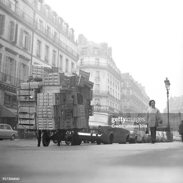 Ein Händler hat seine leeren Kisten auf dem Anhänger gestapelt, aufgenommen im November 1970 in Paris. Nach der Unabhängigkeit der Kolonien in Afrika...