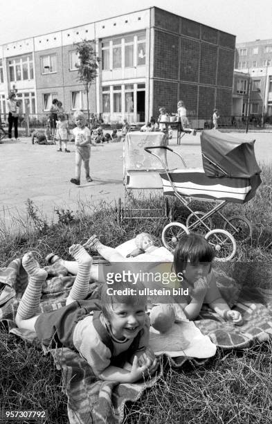 Zwei Mädchen liegen mit ihrem Puppen auf einer ausgebreiteten Decke, aufgenommen im August 1984 in einem Kindergarten in Saßnitz auf der Halbinsel...