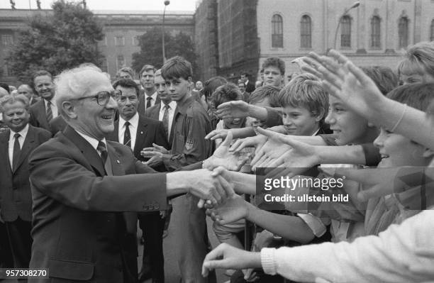 Ostberlin - Erich Honecker, SED-Generalsekretär und DDR-Staatsratsvorsitzender schüttelt die Hände von Jugendlichen, die in der Straße Unter den...