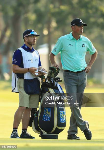 Matt Kuchar of the United States talks with his caddie John Wood on the 11th hole during the second round of THE PLAYERS Championship on the Stadium...