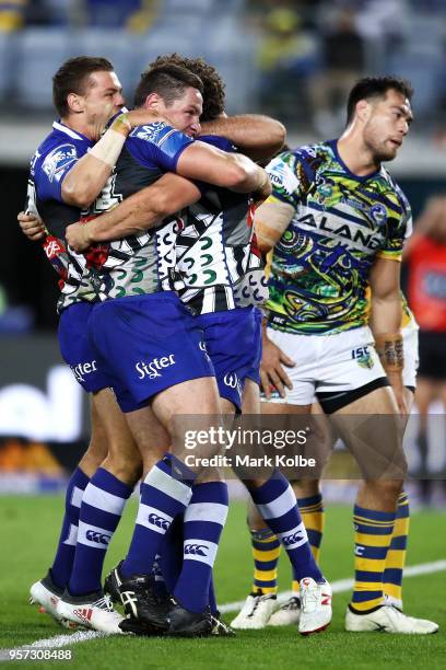 Kerrod Holland and Josh Jackson of the Bulldogs celebrate with Adam Elliott of the Bulldogs after he scored a try during the round 10 NRL match...