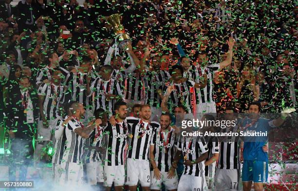 Juventus players celebrate with the trophy after winning the TIM Cup Final between Juventus and AC Milan at Stadio Olimpico on May 9, 2018 in Rome,...