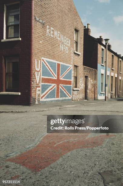 View of a loyalist UVF union jack mural painted on the end wall of a terraced residential Taylor Street, in the Protestant Sandy Row area of South...