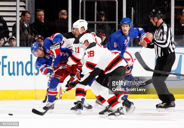Chris Drury of the New York Rangers struggles to gain control of the puck against Dean McAmmond and Vladimir Zharkov of the New Jersey Devils on...