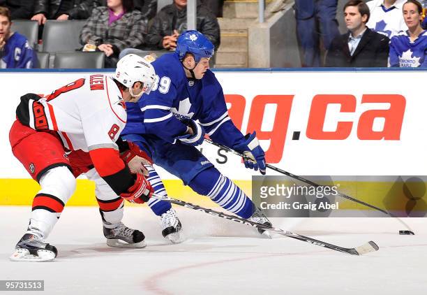 John Mitchell of the Toronto Maple Leafs battles for the puck with Matt Cullen of the Carolina Hurricanes during game action January 12, 2010 at the...