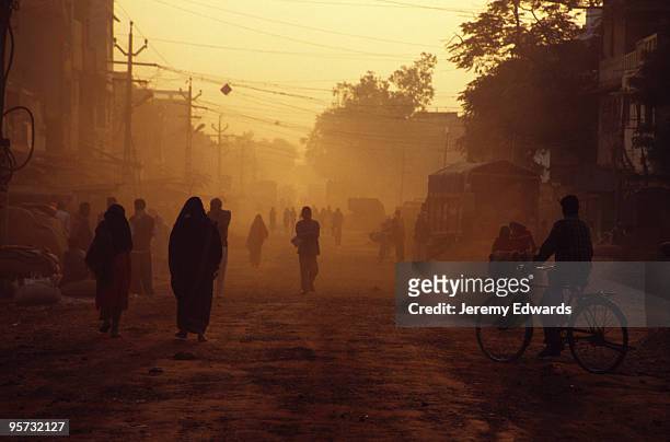 staubige straßenszene - rajasthani women stock-fotos und bilder