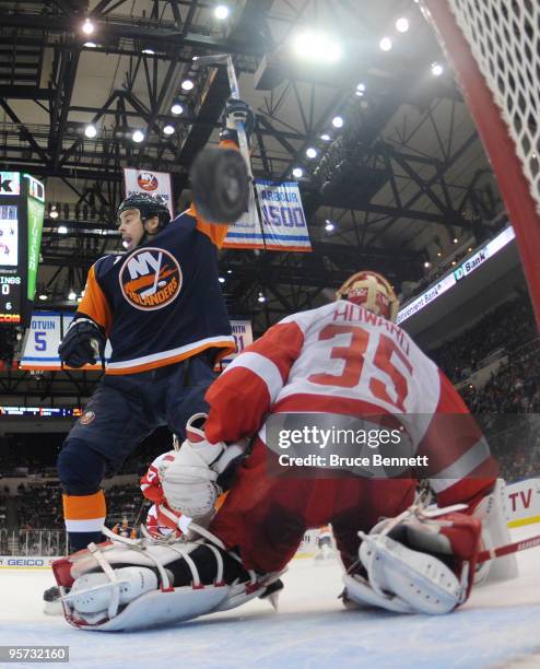 Jimmy Howard of the Detroit Red Wings can't stop a first period shot by Rob Schremp of the New York Islanders as Jon Sim celebrates in front at the...