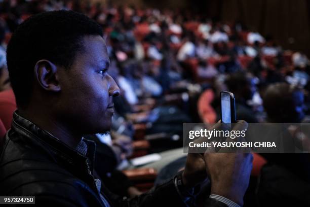 Student records a live transmission using a mobile phone during the public viewing of the deployment of Kenyas first nano satellite from the...